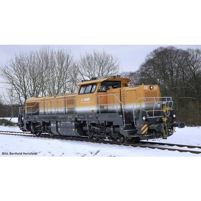 An orange and grey freight locomotive travels along snow-covered tracks. Background: Trees in winter.