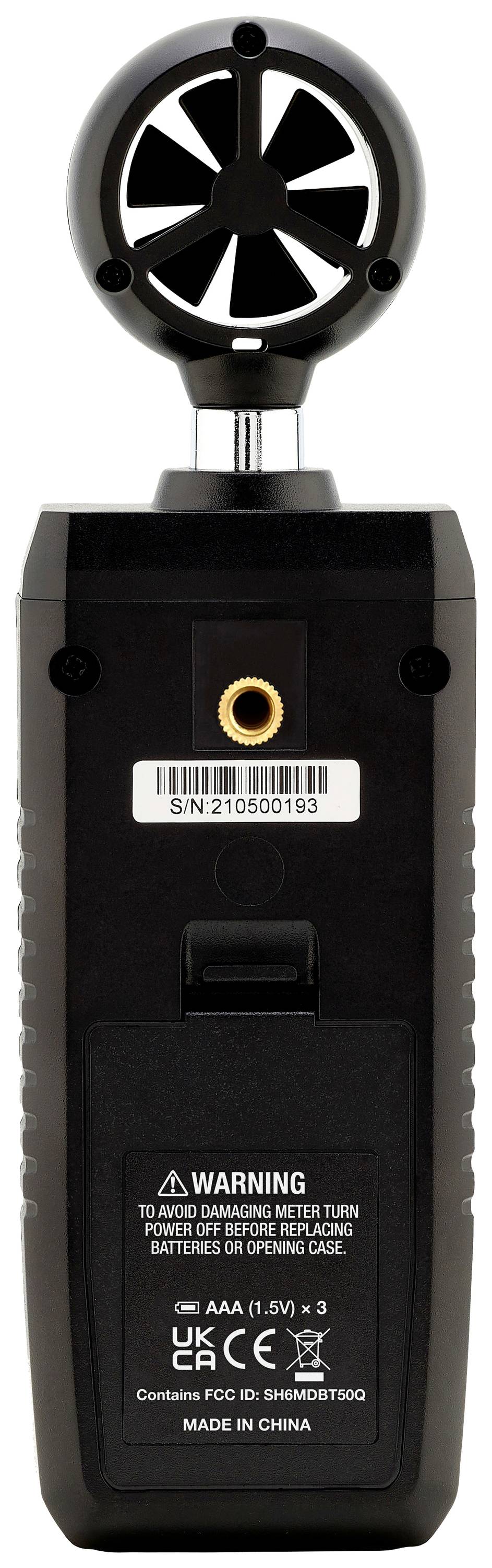 Handheld device viewed from the rear with a circular sensor at the top. Labelling on the device shows warning notices, serial number, and details of manufacturing country and model.