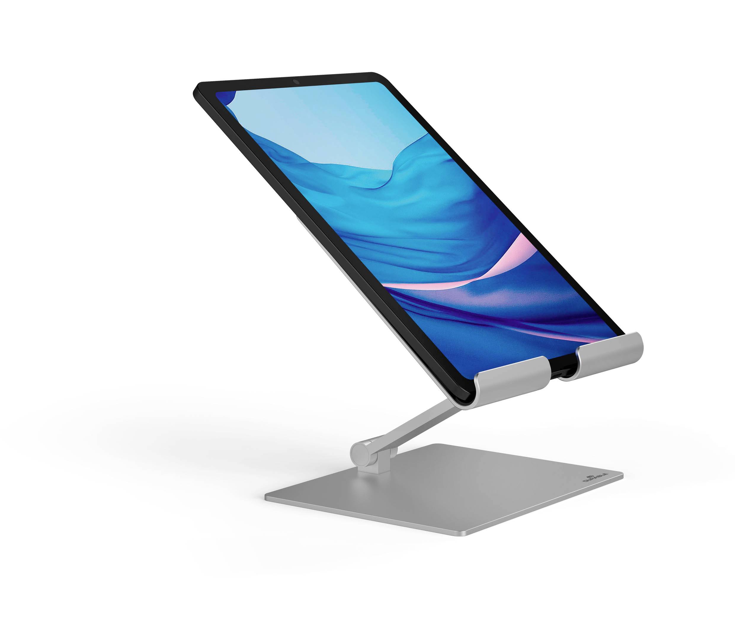 A tablet sits on a silver, adjustable stand, angled slightly upwards. The display shows blue and pink colours.