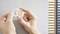 Two hands are holding a round magnetic object against a grey surface.