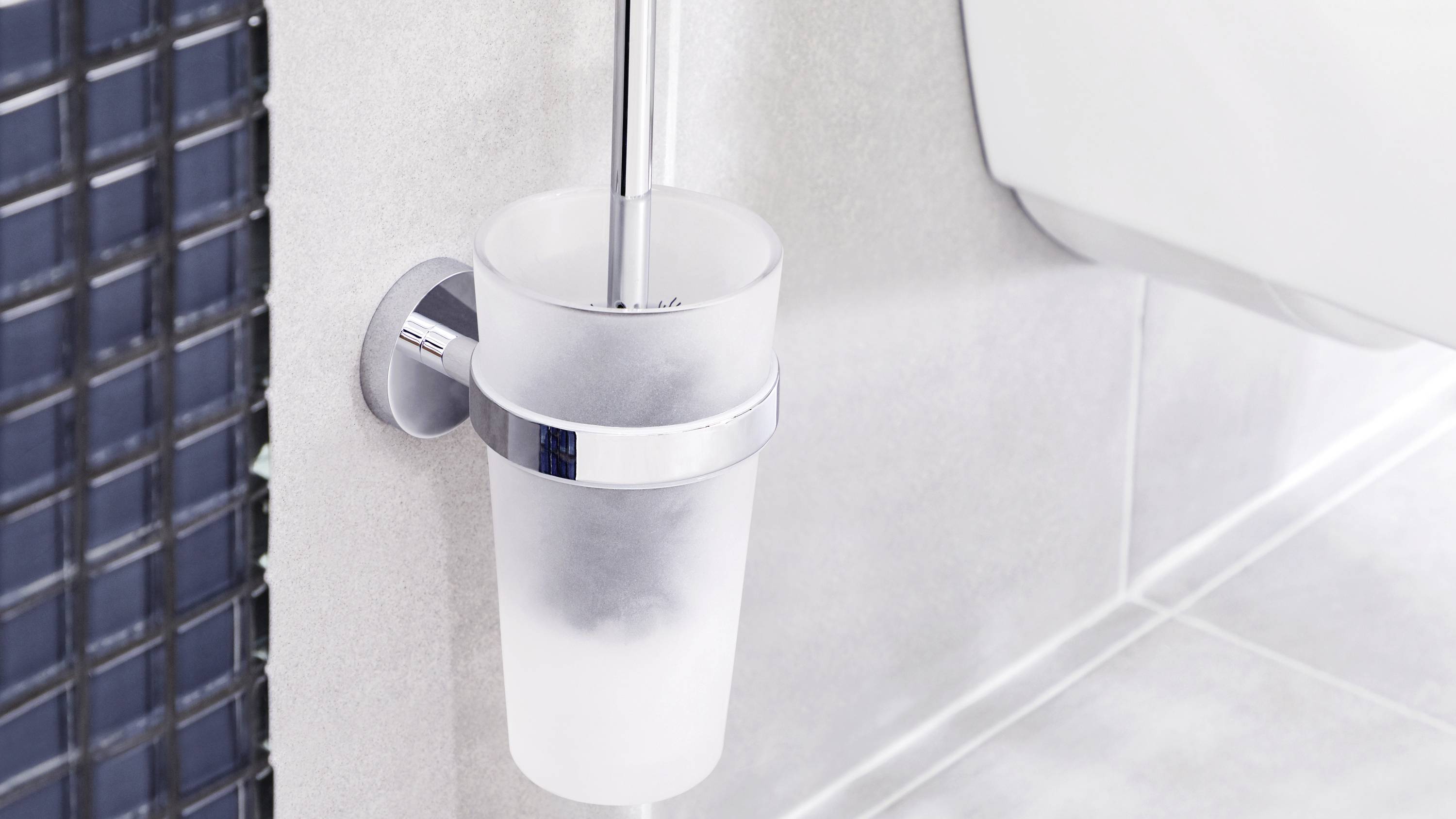 Toilet brush in a wall-mounted holder, part of a modern bathroom.