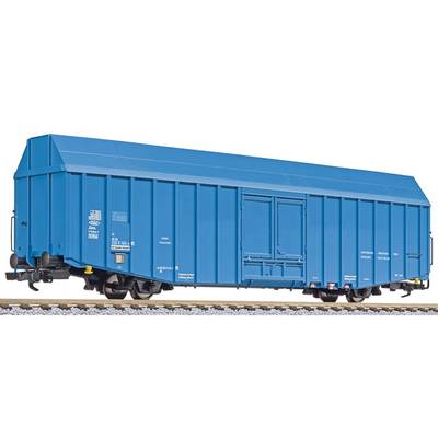 Blue goods wagon on railway tracks, side view, with closed door and markings, in model railway scale.