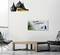 A living room with modern black lamps, a minimalist wooden table and a grey chair. On the wall, a picture with the inscription 'Mindset is everything!', a sheet and office supplies.