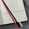 Open notebook with dotted and lined pages. Three bookmarks in different colours are visible.