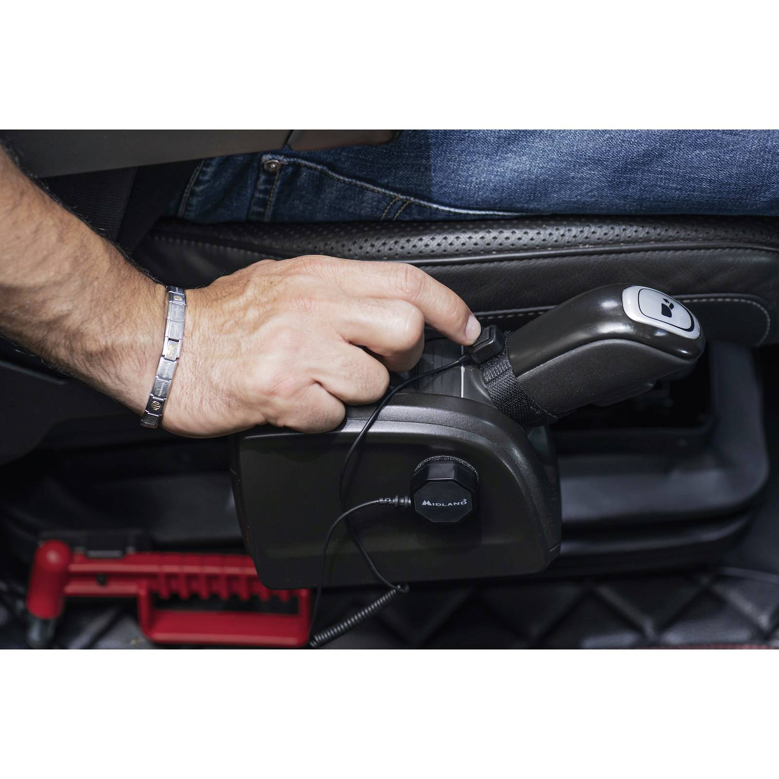 A man operates the lever of a wheelchair control module attached to a seat.