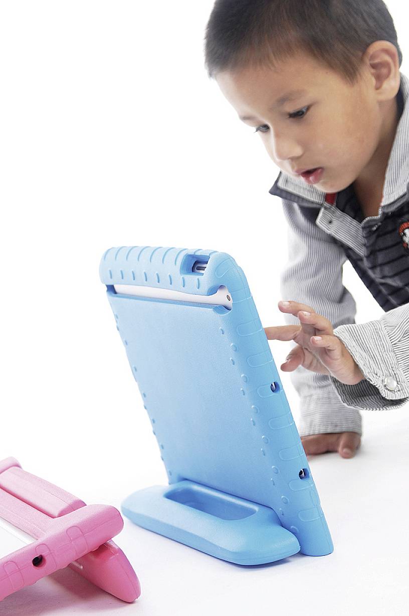 A child is playing intently with a blue electronic tablet while kneeling on the floor.