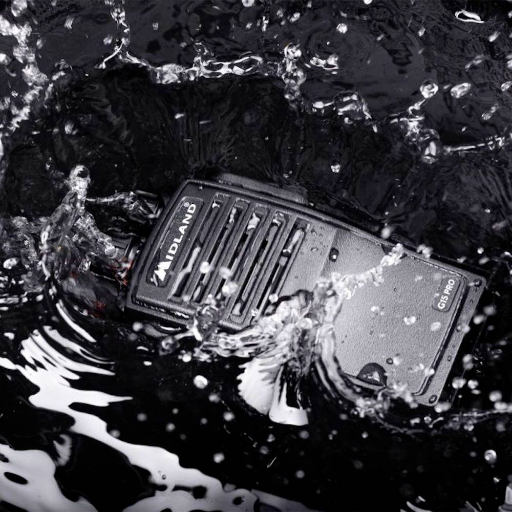 A radio transceiver that repels splashing water demonstrates its waterproof property against a black background.