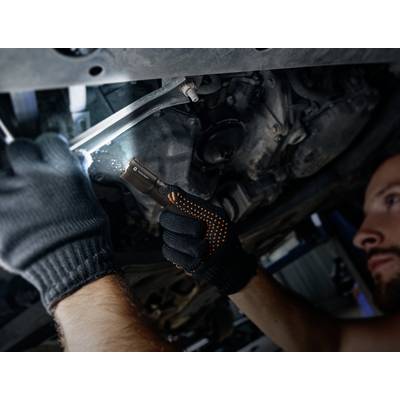 A person is repairing a car under the bonnet, wearing gloves and using a lamp, focused and working on engine components.