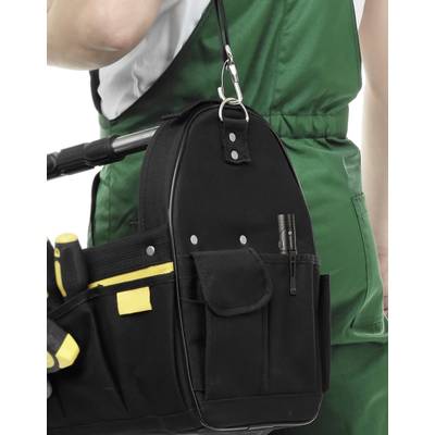 A tradesman in green workwear is holding a black tool bag with yellow and black tools on the side.