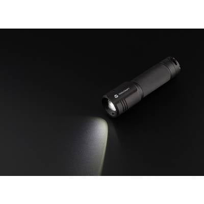 Torch shining diagonally downwards on a black background. The light beam casts a bright cone onto the dark surface.