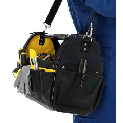 A black tool bag with yellow details, filled with various tools, hangs from the shoulder of a man wearing blue workwear.