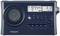 A portable radio in navy blue displays 'FM 97.4 MHz' and the time '3:12' on its display, with numerous control buttons.