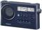 A portable radio in navy blue with digital displays for FM frequency '97.4 MHz' and time '3:12'. A speaker on the left.