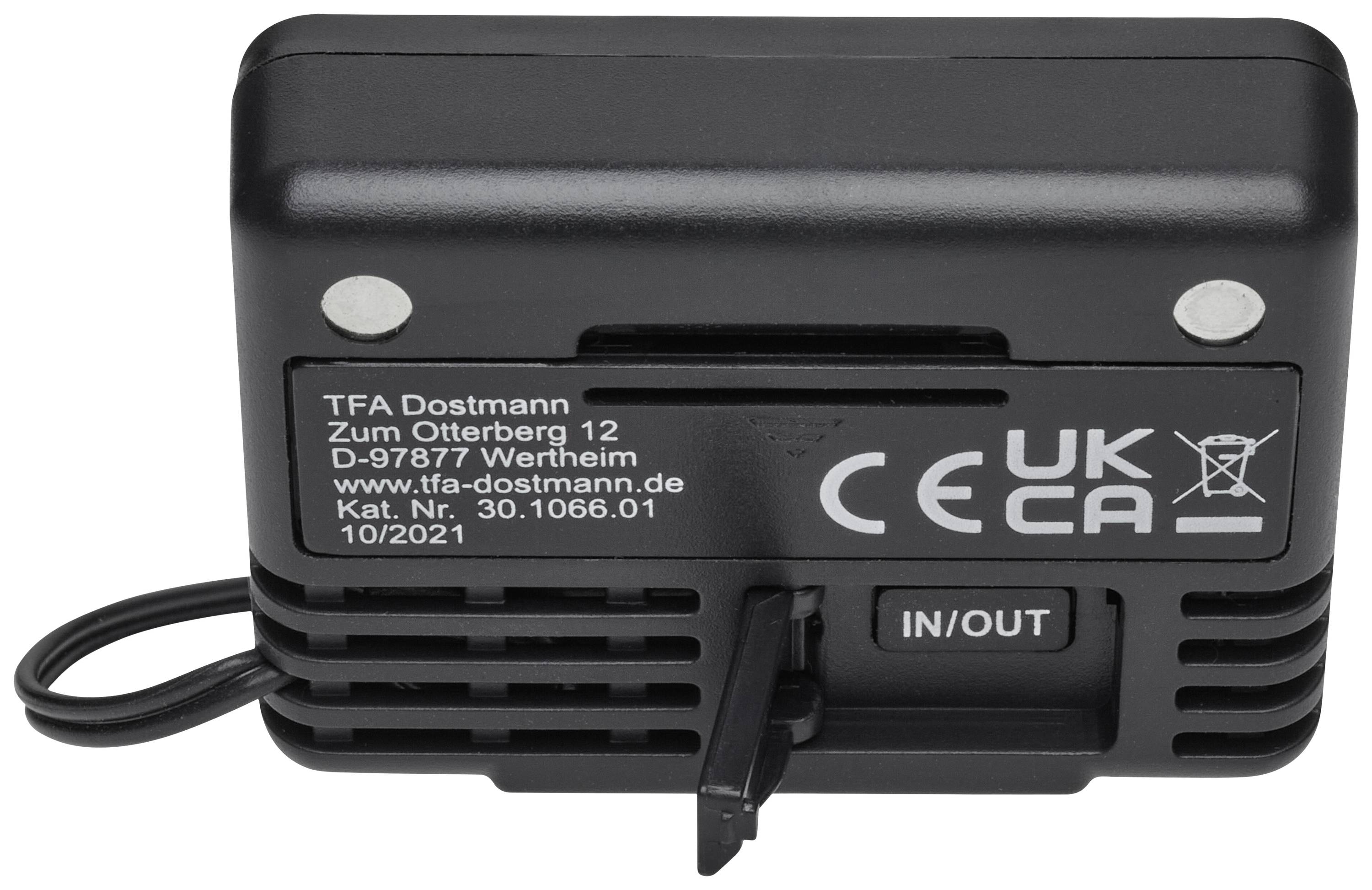 A black device with the inscription 'TFA Dostmann', address, and symbols for CE and UKCA. It has an IN/OUT button and cable connection.
