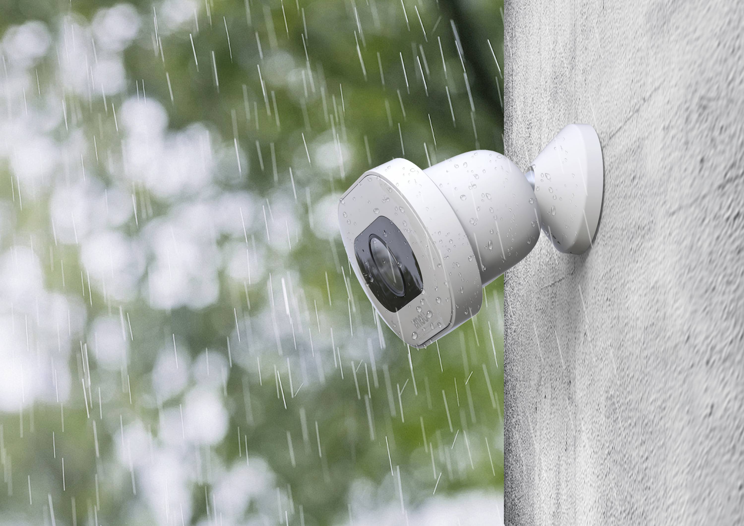 External camera mounted on a wall in the rain, demonstrating security under adverse weather conditions.