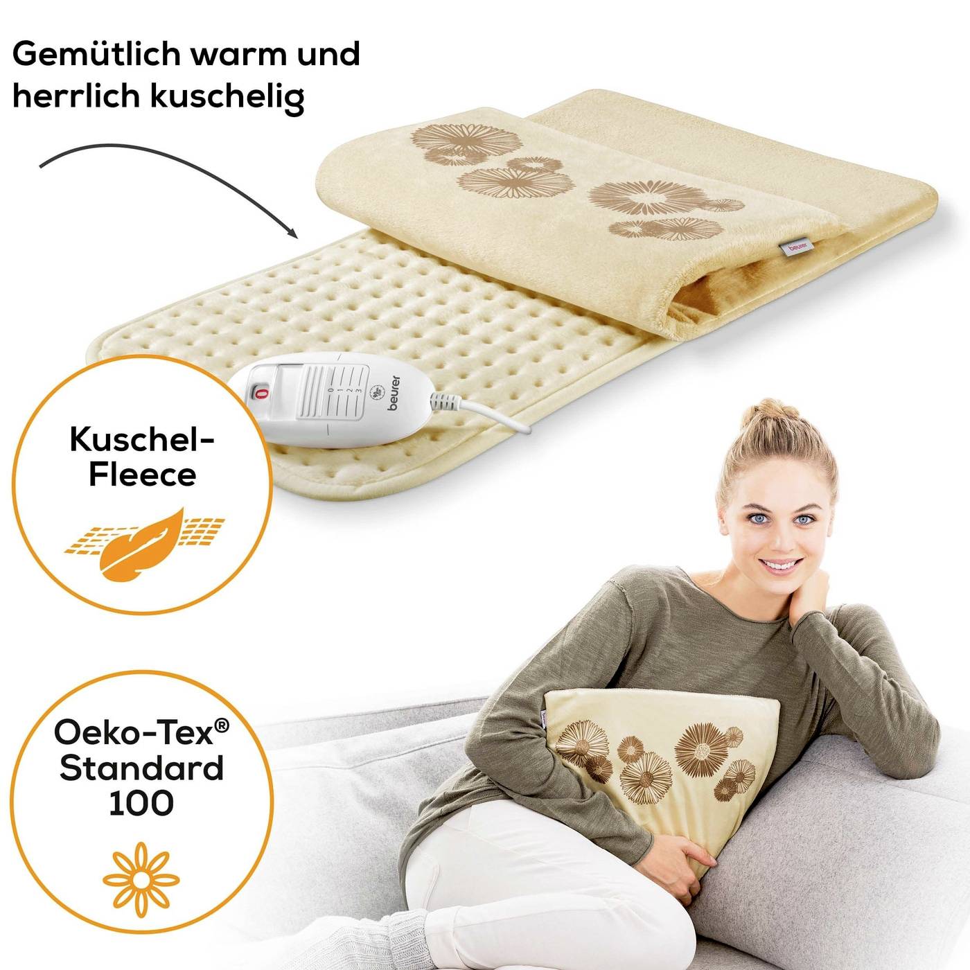 A woman hugs a heated cushion with a floral pattern. Text: 'Cosily warm and wonderfully snug', 'Oeko-Tex Standard 100'.