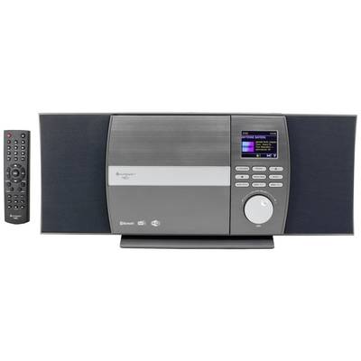 A modern music system with speakers and a colour display in the centre. A remote control lies to the right of it.