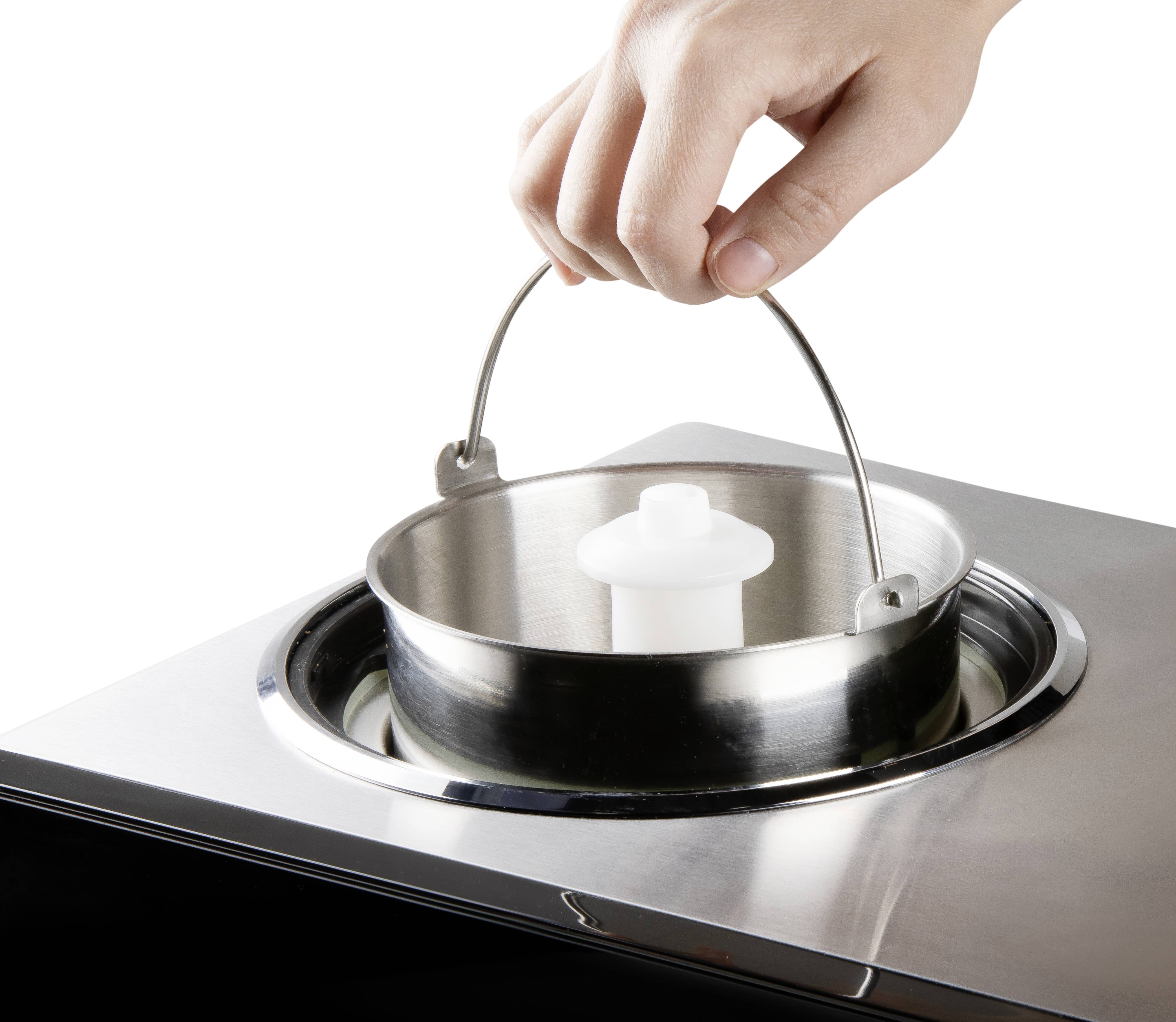 A hand lifts the handle of a removable container from a device. The focus is on the hand movement and the container.