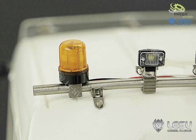 Close-up of a model with a yellow warning light and an LED headlight on a white background.