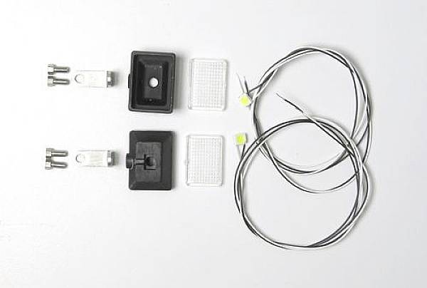 Two LED lights with cables, two mounting brackets, two black housings and two transparent covers on a white background.