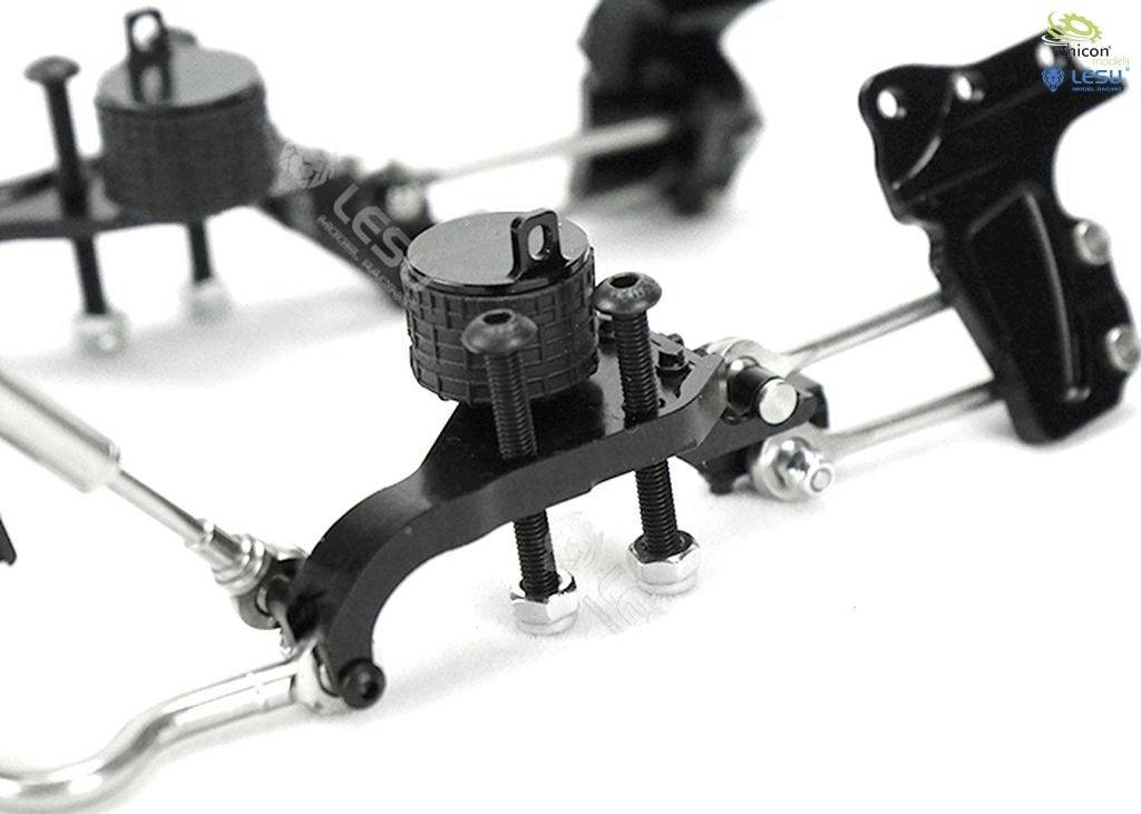 Close-up of a mechanical component with black cylinders and silver screws. It appears to be part of a vehicle chassis or suspension system.