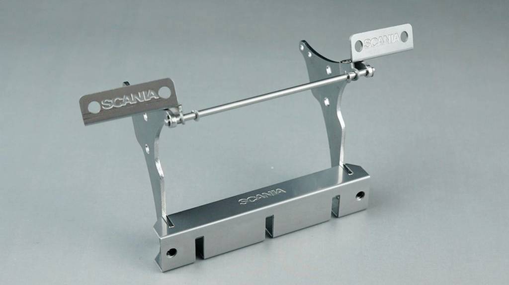 Metallic device with the 'SCANIA' logo on a grey background. It consists of a frame with two upright supports.