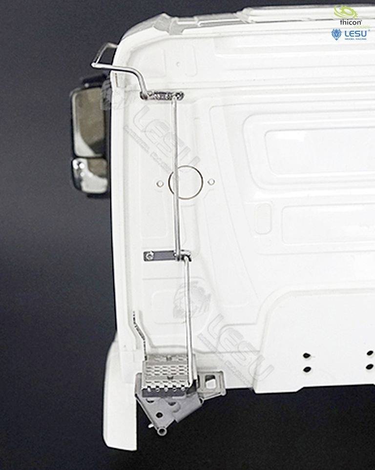 A white vehicle component with metal steps. A side wing mirror is visible in the top left.