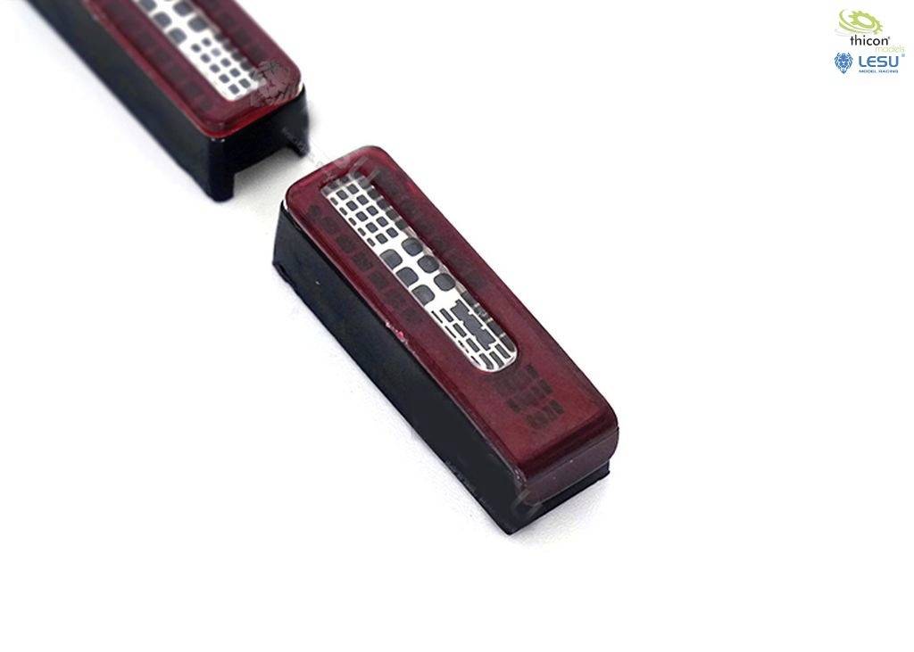 A rectangular electronic component with red and silver elements, possibly a sensor or display, lies on a white background.