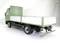 A green lorry with an open flatbed is positioned sideways on a white background. There is no visible cargo.
