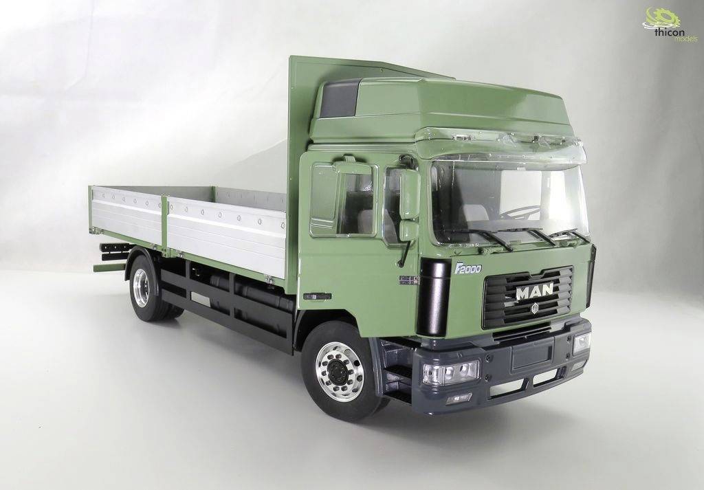 Green MAN lorry with open cargo area, photographed against a neutral background.