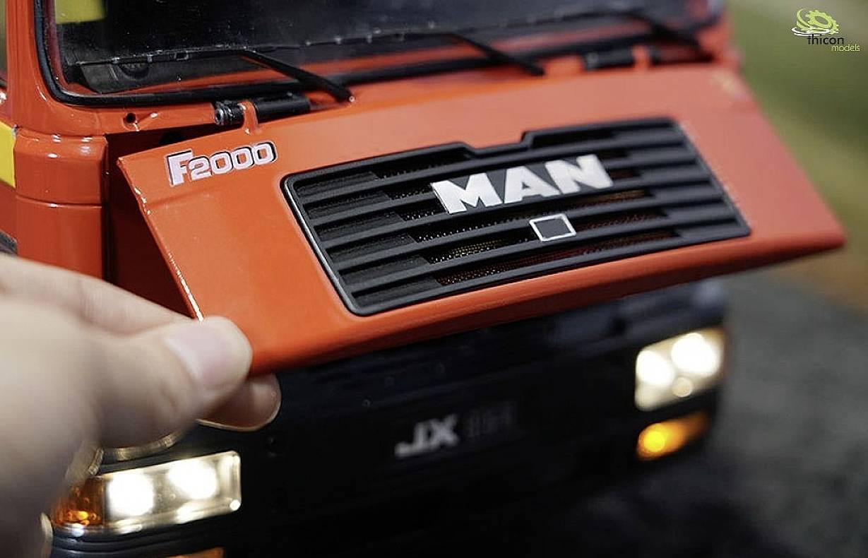 A model vehicle by the brand 'MAN' with an open bonnet clearly shows the brand name. The main focus is on the front emblem.