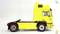 A yellow, model-like lorry cab without a trailer on a white background. It shows the side view of the vehicle.