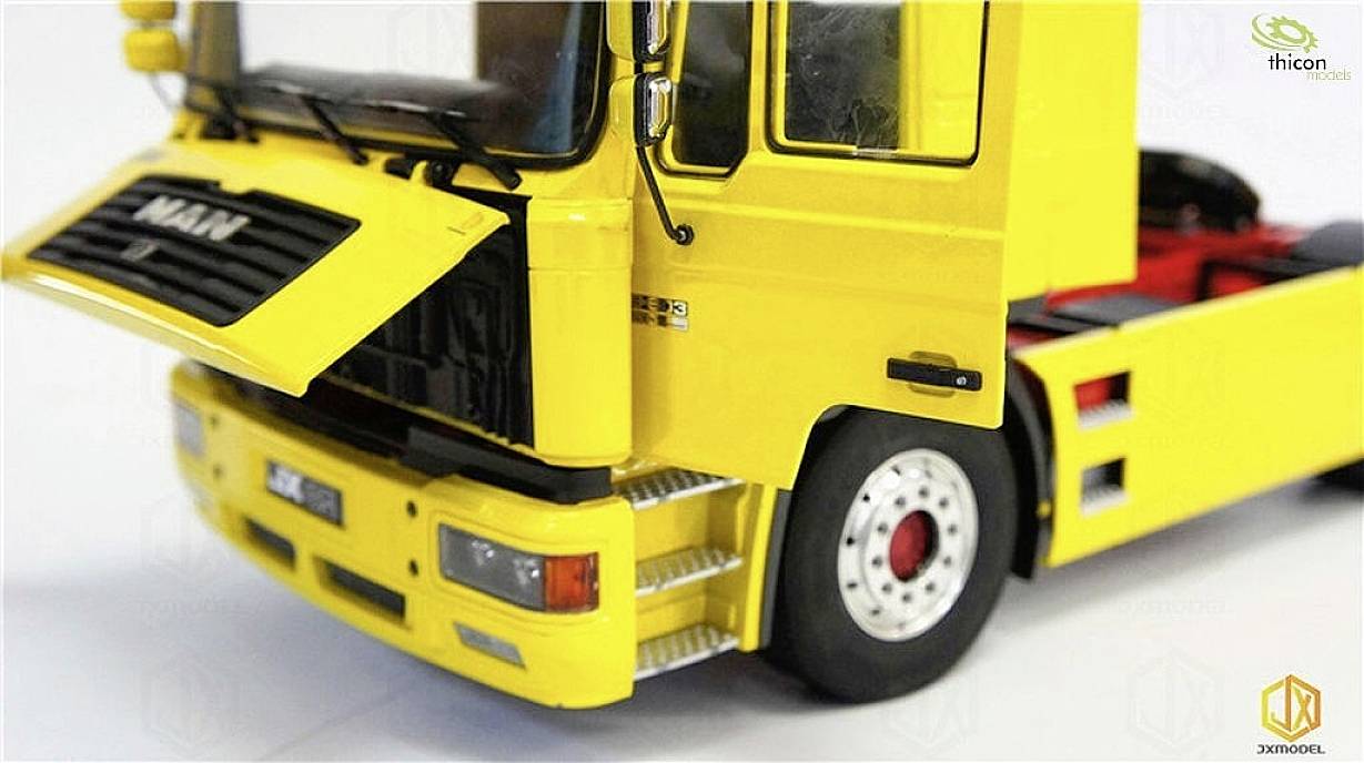 Yellow model of a lorry with an open bonnet, showing the front and part of the driver's cab. Brand logo visible.