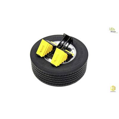 'Two yellow wheel chocks on a stack of three tyres.'