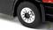 Close-up of a lorry tyre with a silver wheel rim. The tyre is attached to a black lorry. A logo is positioned in the top right corner.