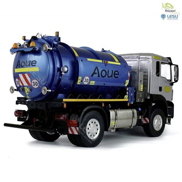 A silver refuse collection lorry with a blue waste container, yellow stickers, and the inscription 'Aoue' on the container.