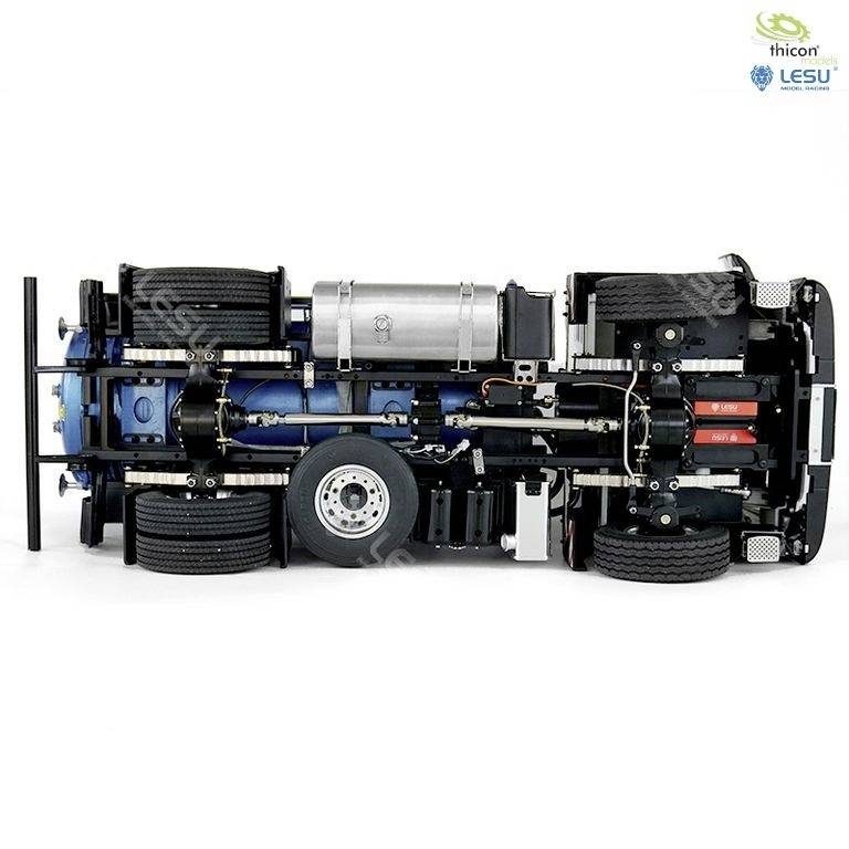 The image shows the underside of a blue model lorry with visible mechanical parts, wheels, and a silver tank.