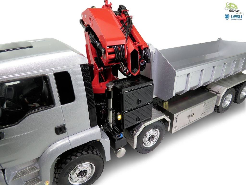 Grey lorry with a red crane attachment located beside the cab. The crane is raised and pointing upwards.