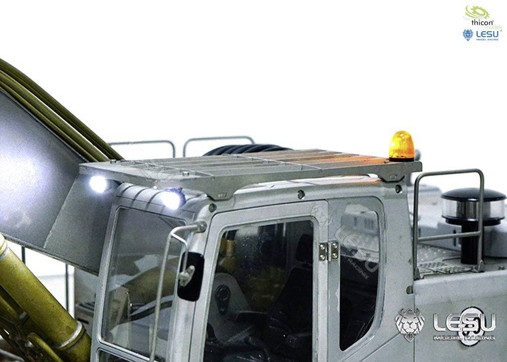 Close-up of a silver toy construction vehicle with a glowing orange light on the roof and LED headlights.