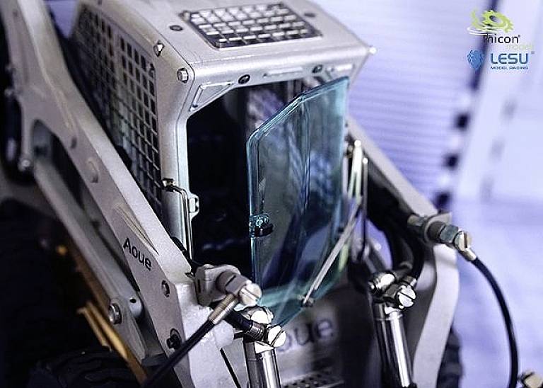 A remote-controlled model vehicle with an open cockpit and visible protective glass. 'thicon' and 'LESU' logos are positioned in the top right.