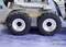 'Close-up of a model vehicle with four robust tyres on rough terrain. Logos are visible in the top left and bottom right.'