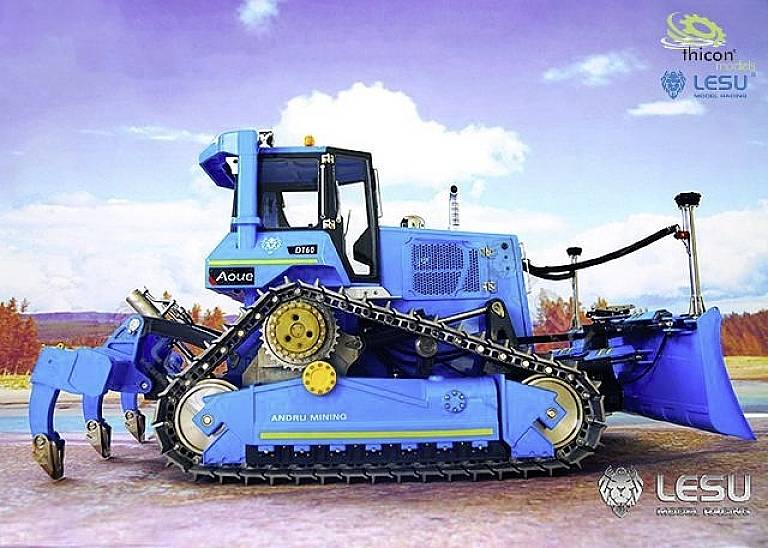 A blue excavator on a construction site with company logos in the background. The excavator has caterpillar tracks and is equipped with a digging arm.