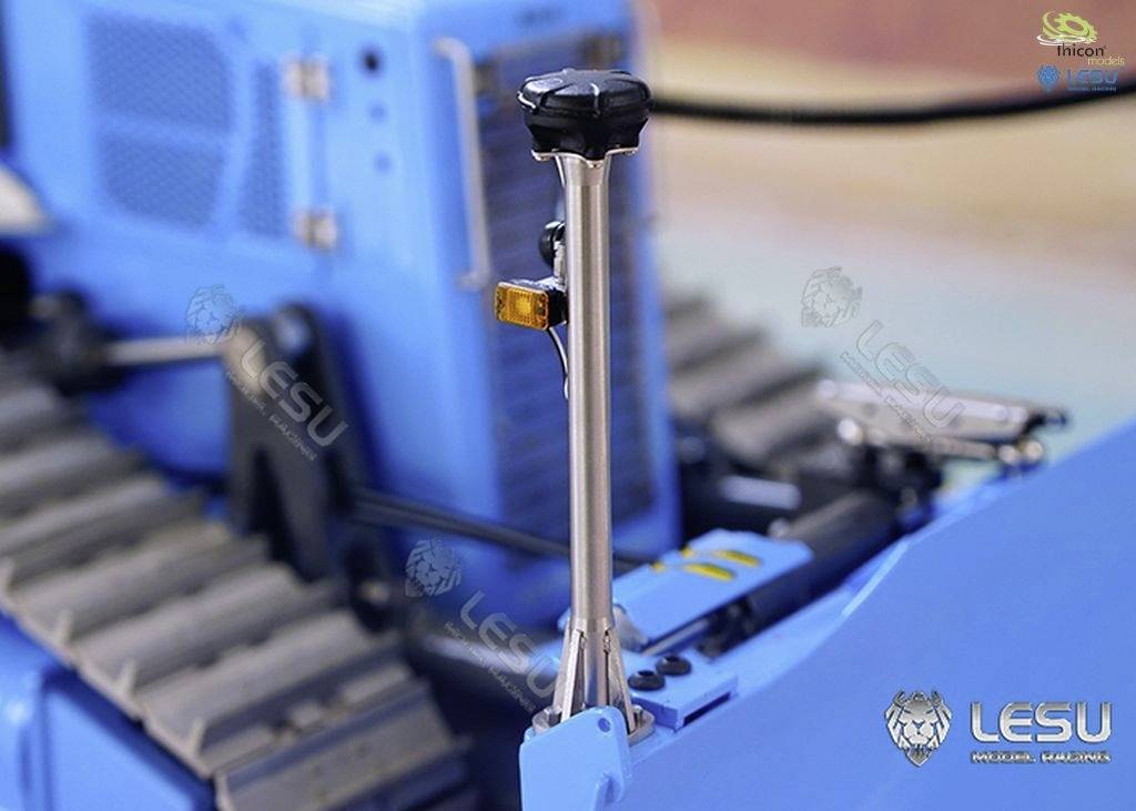 Close-up of a blue model vehicle with movable parts, a vertical metal pin prominently visible.