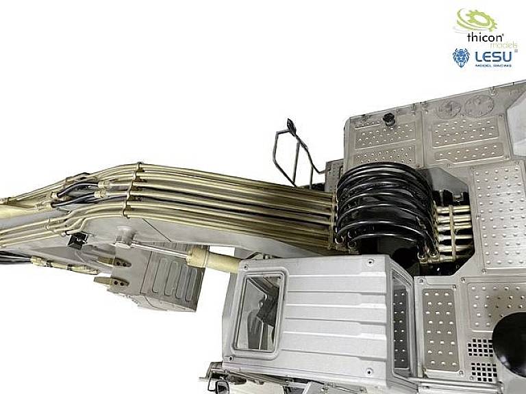 Hydraulic components of a model excavator arm with multiple hoses and pipes, depicted in chrome finish. Logos in the top right corner.