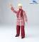 A doll wearing a checked coat and red scarf raises a hand, standing against a light background.