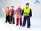 A group of four dolls in workwear stands in a row. One doll is wearing a yellow hi-vis vest. Brand logo in the corner.