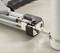 A tensioning tool tightens a band around the end of a round package to secure it for transport.