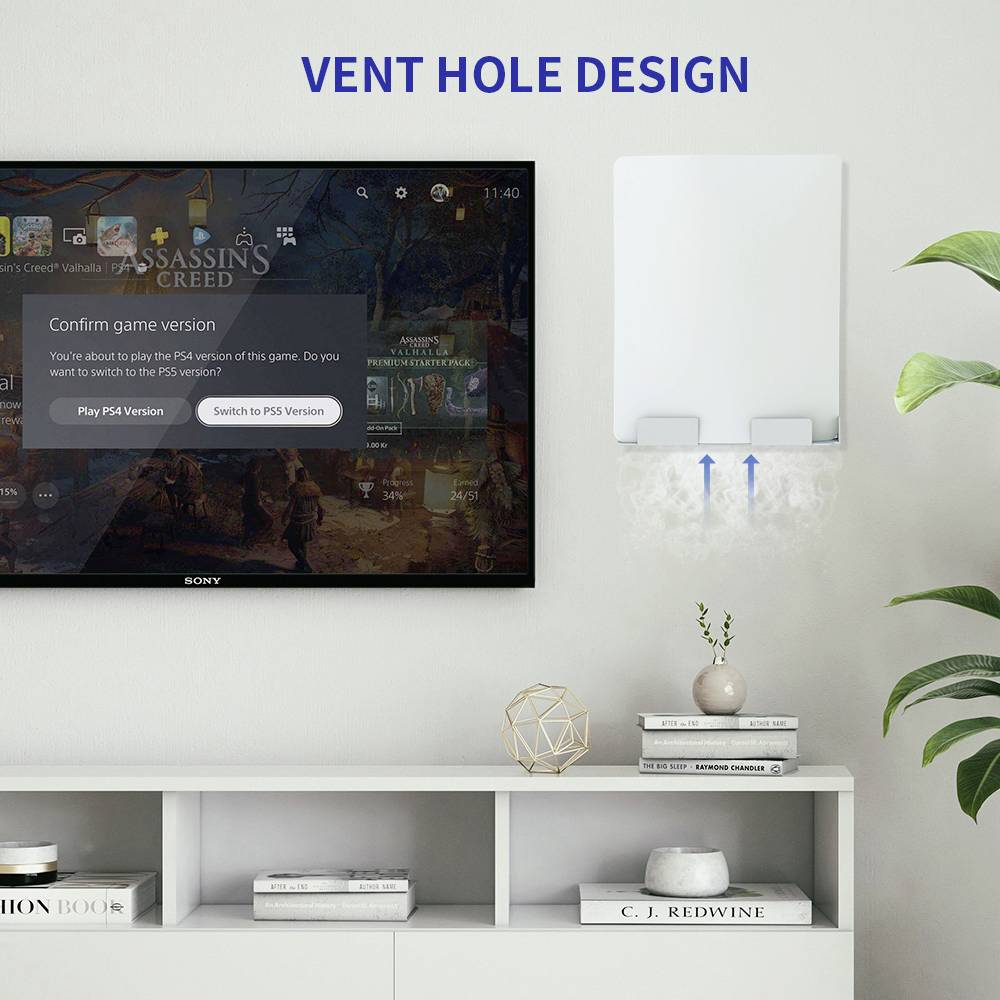 Flat-screen television mounted on the wall above a white shelf with decorative items. To the right, a white device with ventilation holes and downward-pointing arrows.