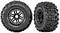Two black off-road tyres with a rugged tread pattern. The tyre on the left viewed from the side, the tyre on the right viewed from the front.