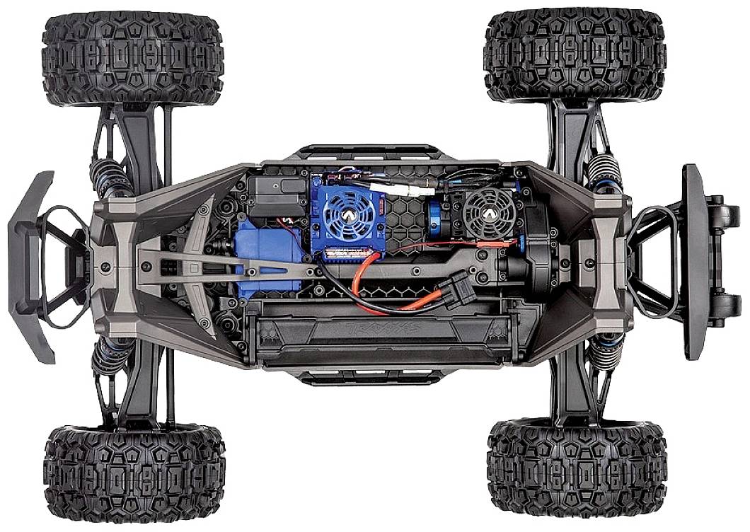 Remote-controlled car viewed from underneath, revealing detailed technology and electronics with visible cables, fans, and robust tyres.